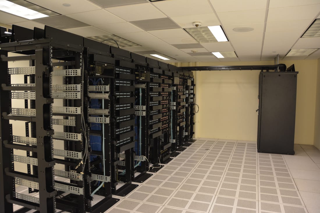 Interior de um data center com racks de servidores e cablagem